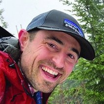 Gabe Shulman smiling outdoors in a cap